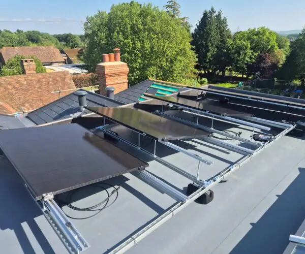 Ground-mounted solar panel array in a landscaped garden with rural surroundings